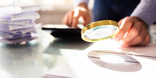 Person går igjennom økonomien med lupe